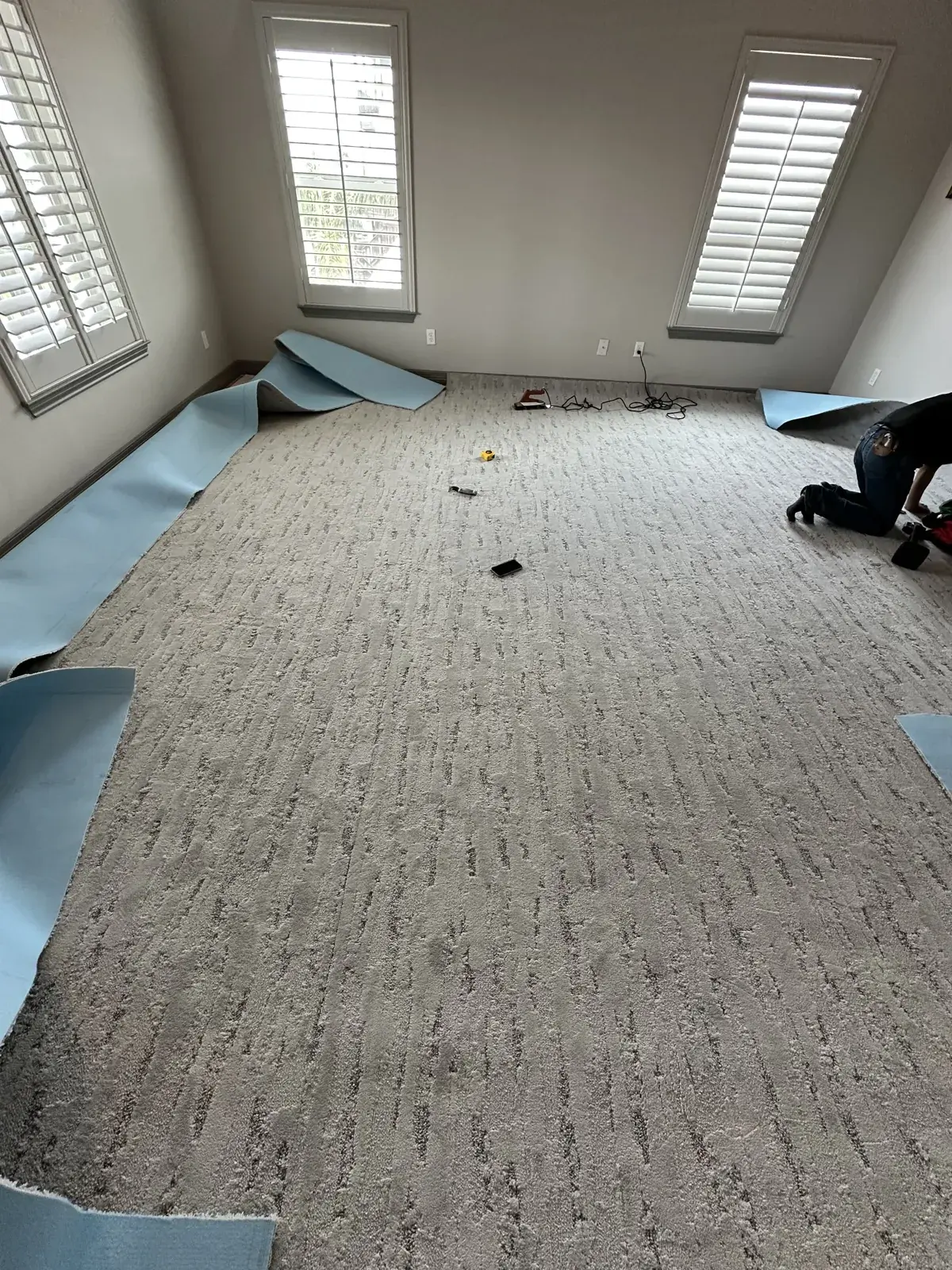 Patterned carpet being installed in a bright room in Conroe, TX